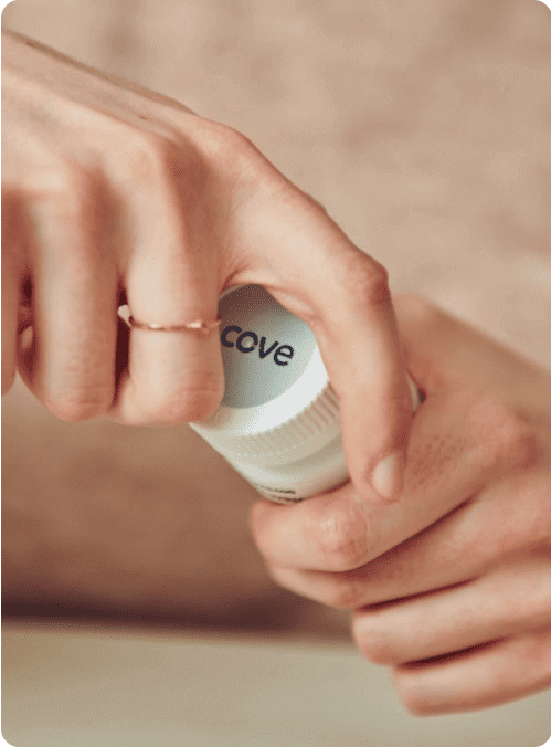 Woman's hands opening a bottle of migraine medication.