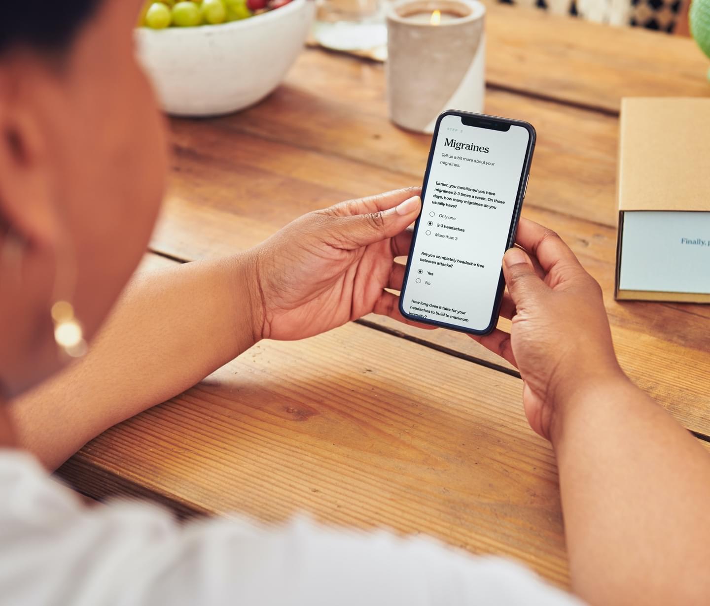 A woman viewing the Cove migraine consultation on her mobile phone.